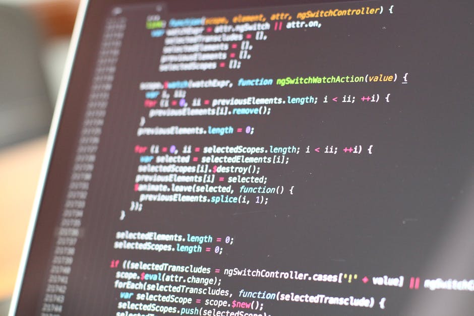 A close-up photograph of a computer screen displaying a digital code or programming interface, with lines of multicolored text primarily in red, green, blue, and purple against a dark background. The 